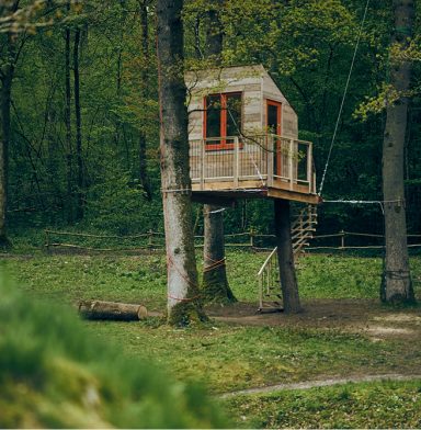 Zwevende boomhut in steigerhout als tuinkantoor
