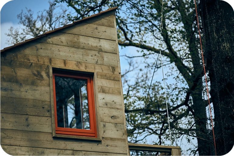 Boomhut bouwen in steigerhout met dak in red western cedar shingles en oranje ramen