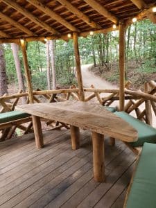 Boomhut terras met tafel en bank onder een afdak